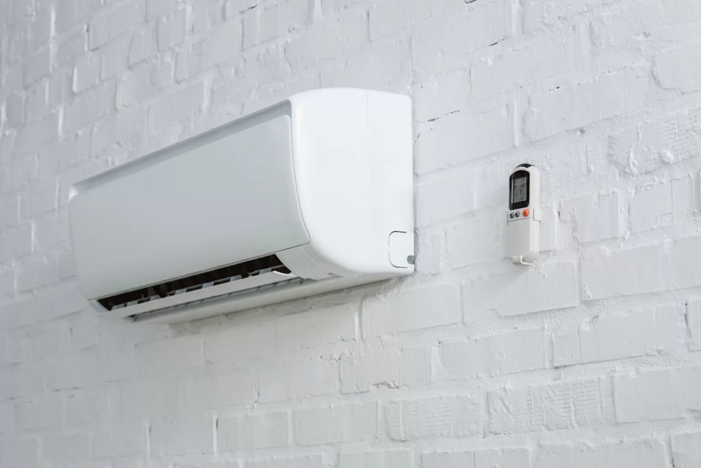a white air conditioner on a brick wall